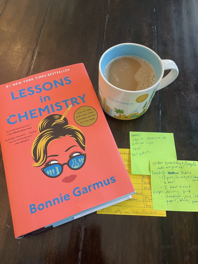 A copy of Lessons in Chemistry accompanied by to do lists and a cup of coffee.